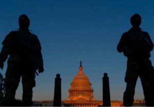 FILE - National Guard soldiers stand their posts around the Capitol at sunrise in Washington, March 8, 2021.