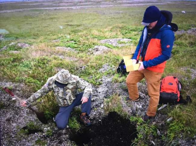 Ian Putnam (right), a Coast Guard physical scientist, and Edmund Gaines, a Coast Guard-contracted archaeological consultant, prepare to repatriate unidentified Alaska Native remains at Point Spencer, Alaska, Aug. 12, 2021. The two returned the remains to the site where they’d been accidentally collected during an archaeological excavation on Coast Guard-owned property, near the former Long Range Aids to Navigation (LORAN) C Station at Port Clarence. Image-Petty Officer 1st Class Nate Littlejohn