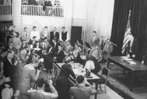 Bill Egan, president of the convention and a future governor, signs the proposed Alaska Constitution in the gymnasium, now Signers’ Hall, on Feb. 5, 1956 followwing Alaska's first Constitutional convention. Image-UAF