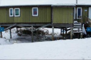 The amount of subsidence can be inferred by the distance from the bottom step to the ground in this photo of a building in Point Lay. Photo by Bill Tracy