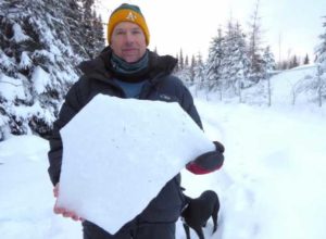 Ned Rozell holds a shard of ice crust, one inch thick, that lurks in the middle of the Fairbanks snowpack. Image-Kristen Rozell