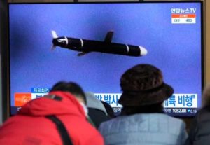 People watch a TV showing a file image of North Korea's missile launch during a news program at the Seoul Railway Station in Seoul, South Korea, Jan. 25, 2022.