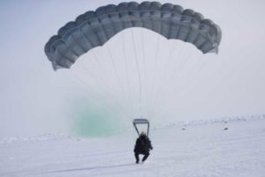 A 212th Rescue Squadron combat rescue officer lands at the U.S. Navy’s Ice Camp Queenfish on the arctic ice pack. (U.S. Air National Guard photo by Master Sgt. Benjamin Westveer)