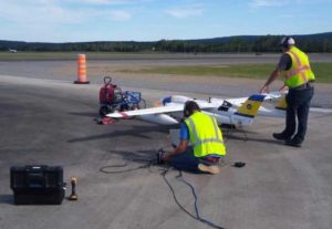 ACUASI  team members Joncy Walden and Justin Humphrey tune the fuel injection on a Sea Hunter's left engine in Canada. Image- Andrew Wentworth