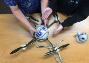 Students get hands-on activity at an education outreach session at Delta Junction Junior High School in July. Here, two students reassemble a drone that Adkins has taken apart. Photo by Rod Boyce.