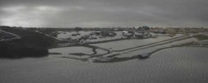 A Coast Guard Air Station Kodiak aircrew flies over Golovin, Alaska, to assess damage to houses and facilities, September 18, 2022. Coast Guard crews are responding to impacted communities following a historic storm, Typhoon Merbok, that hit Alaska's western coast. U.S. Coast Guard photo by Petty Officer 3rd Class Ian Gray.