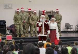Santa and Mrs. Claus share holiday cheer with children at the local school during Operation Santa Claus in Scammon Bay. (Alaska National Guard photo by 1st Lt. Balinda O’Neal)