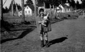Photo: Girl in Ouzinkie with stuffed rabbit toy. Melinda Lamp Collection.
