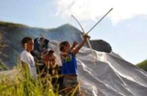 Boys learn to shoot a bow and arrow, Akhiok Petroglyph Camp, Cape Alitak.