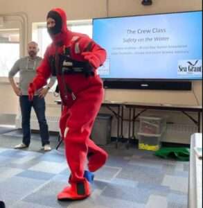 Instructors Gabe Dunham (l) and Tav Ammu teach proper use of an immersion suit. Photo by Alaska Sea Grant.
