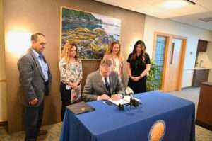 Governor Mike Dunleavy signs SB 58 at the Anchorage Women's Clinic.