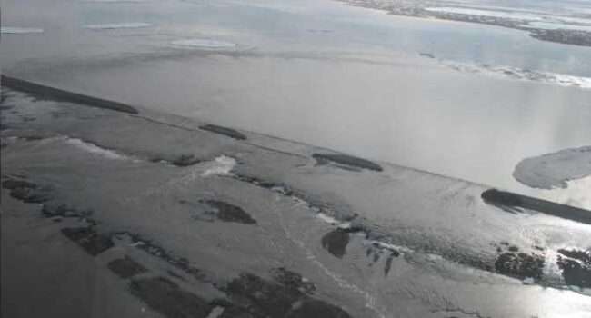 FGloodwaters flow over and erode the Dalton Highway 0n May 21,2015. The flooding contributed to a slow subsiding of ground in the permafrost rich region. Photo courtesy of the Alaska DOT&PF