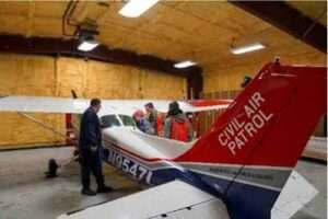 Civil Air Patrol Lt. Col. Stephen Sammons, left, Alaska Wing emergency services officer, instructs CAP cadets from the Southcentral Region where to find an Emergency Locator Transmitter onboard a Cessna 172 aircraft during a three-day training event Nov. 4. (Alaska National Guard photo by Dana Rosso)