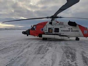 A Coast Guard Air Station Kodiak MH-60 Jayhawk helicopter crew sits on the ground in Nome after recovering two stranded hunters from the Punuk Islands, near St. Lawrence Island. U.S. Coast Guard photo by Lt. Daniel Beshoar.