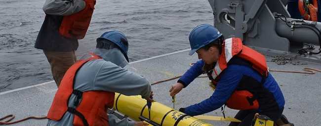 Researchers prepare to deploy a glider instrument into the ocean. (Photo by Rebecca Travis/Woods Hole Oceanographic Institution)