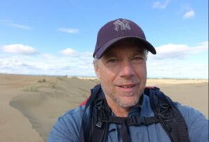 Photo by Ned Rozell
Ned Rozell hikes a sandy ridge at western Alaska’s Nogahabara Dunes in summer 2024.