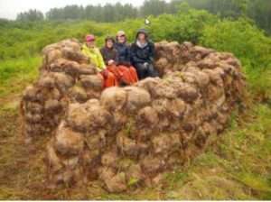 Photo: Archaeologists sitting on a pile of sod blocks. King Salmon River area, Alaska Peninsula.
