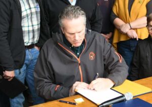 Governor Dunleavy signing bills at the State Fair. Image-Office of Governor Dunleavy