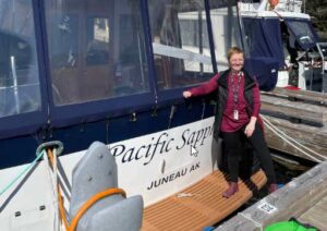 Photo courtesy of Sarah Lewis. Sarah Lewis stands at the stern of the Pacific Sapphire, on which she will travel to Southeast Alaska communities to teach classes about healthy living and preserving food safely and to conduct canner gauge tests.