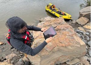 Photo by Patrick Druckenmiller, UA Museum of the North
Florida State University graduate student Tyler Hunt scans a rock that contains several dinosaur footprints during a recent trip on the upper Colville River.