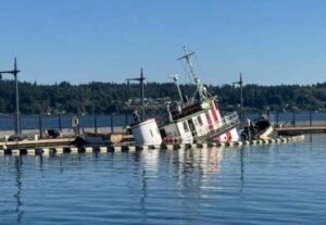 A tug begins to sink near in the Bremerton Marina, near Bremerton, Washington, Sept. 17, 2025, causing pollution. Coast Guard Sector Puget Sound received an initial pollution report from the National Response Center regarding the vessel Dominion, a 130-foot tugboat, sinking and leaking fuel and oil within the marina. (Photo Courtesy of the Washington Department of Ecology)

