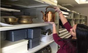 Photo: Rebecca Pruitt stores a copper kettle donated by Larry Matfay in the museum's collections.
