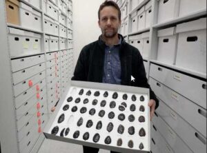 hoto by Ned Rozell
Archaeologist Jeff Rasic holds a tray of obsidian tools found in the Nogahabara Dunes west of the Koyukuk River.