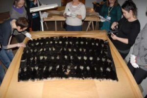 Photos: Skin sewers examine a blanket of bird pelts, National Museum of Finland, 2013.