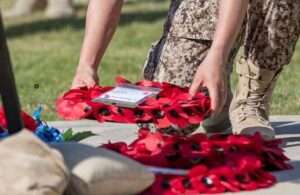 Military member laying poppy wreath. (U.S. Army photo by Sgt. Angela Lorden)