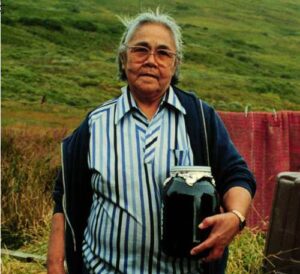Photo: Phyllis Peterson holds a jar of berries preserved in oil, an ingredient in Tugluq. Photo by Priscilla Russell, Kodiak Area Native Association Collection.
