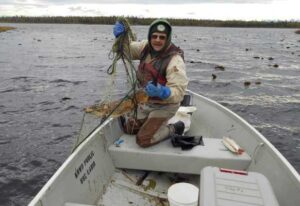 Photo by Rob Massengill/ADFG
Alaska Department of Fish and Game technician Jerry Strait catches a northern pike in Vogel Lake in 2019.