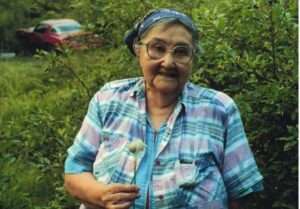 Photo: Alutiiq Elder with cotton grass, photo by Priscilla Russell, KANA Collection. Photo by Priscilla Russel. AM4.113.