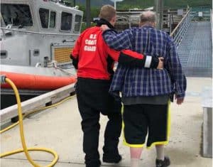 A Coast Guard Station Valdez crew member assists a 72-year-old man off the pier in Valdez, Alaska, after rescuing him from the 33-foot vessel Study Beauty. U.S. Coast Guard photo by Petty Officer 3rd Class Alexander Sheltra.