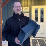 Photo by Molly Simons Tom Marsik holds an Arctic Dual Hood he and his team developed in front of Ventilation Solutions in Fairbanks, where the hoods are now available.