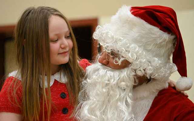 Santa talks to Chloe Stone of Chiniak,  at the Chiniak School during the Coast Guard-sponsored Santa to the Villages event, Dec. 6, 2022.