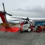U.S. Coast Guard Air Station Kodiak MH-60 Jayhawk helicopter aircrew and Alaska Air National Guard pararescuemen prepare to depart on a flight in Adak, Alaska, Sep. 29. 2026. The two teams worked together to successfully medevac a cargo vessel captain experiencing a medical emergency 58 miles off the coast of Adak. (U.S. Coast Guard photo by Lt. Cmdr. Tanner Evans)
